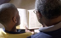 Older man and boy studying the Bible