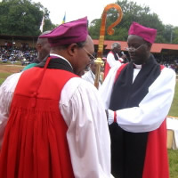 Rwanda_R_Archbishop Emmanuel Kolini hands Bishop Nathan Gasatura the bishop's staff